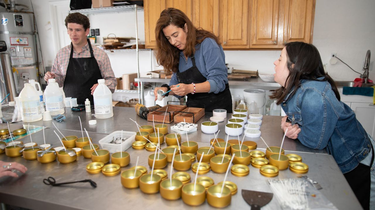 Blissful Seeds team hand pouring soy candles together in the Poway workshop