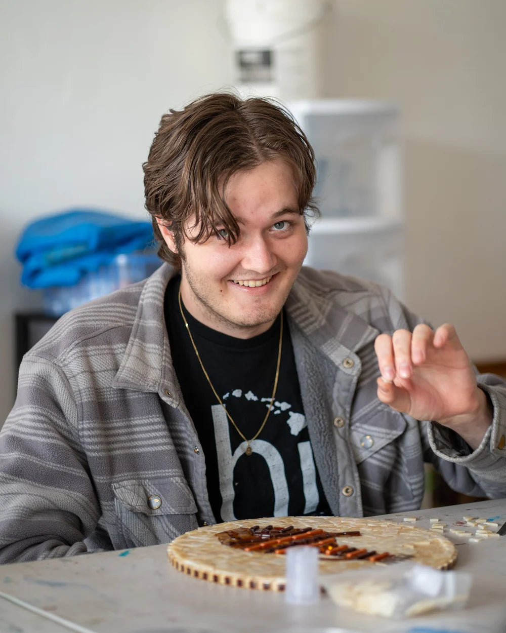 Blissful Seeds artist Owen working on a round mosaic at the worktable