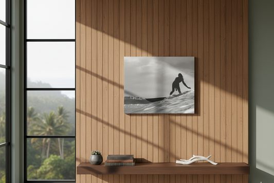 Sliding Terra Mar Point black-and-white surf photo on canvas, a surfer riding a wave, hung on a wood-slat wall above a shelf